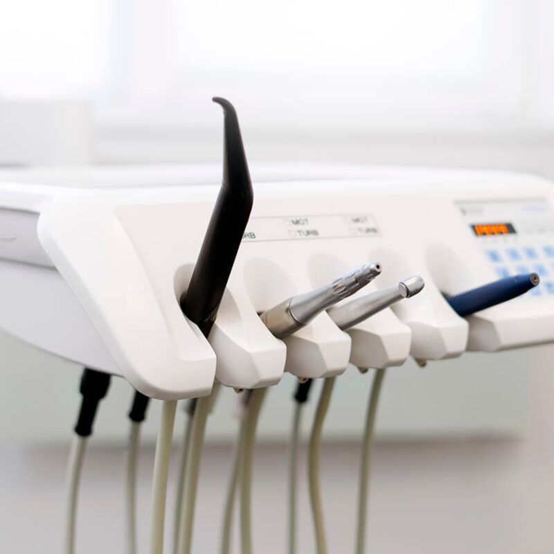 The unit holds various dental handpieces